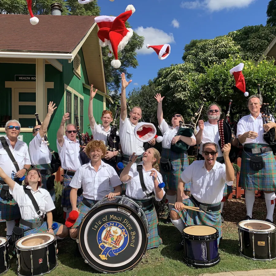 Band members in Santa hats cheering beside the bass drum