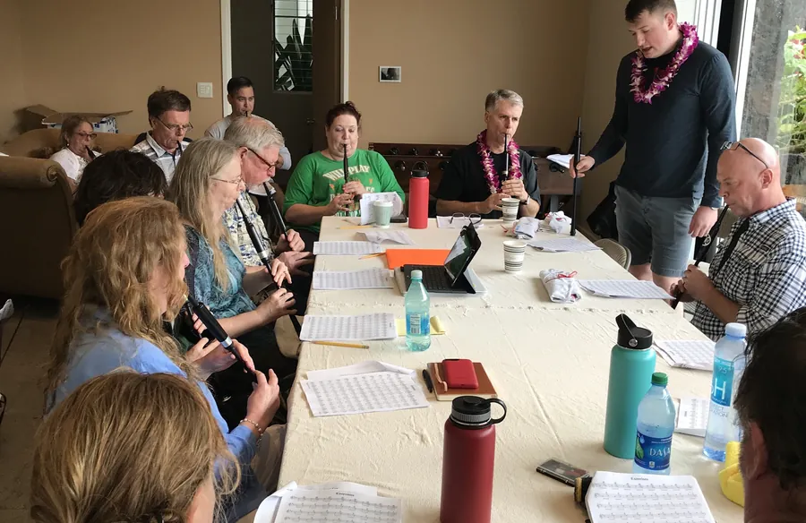 Students practicing chanters around a long table